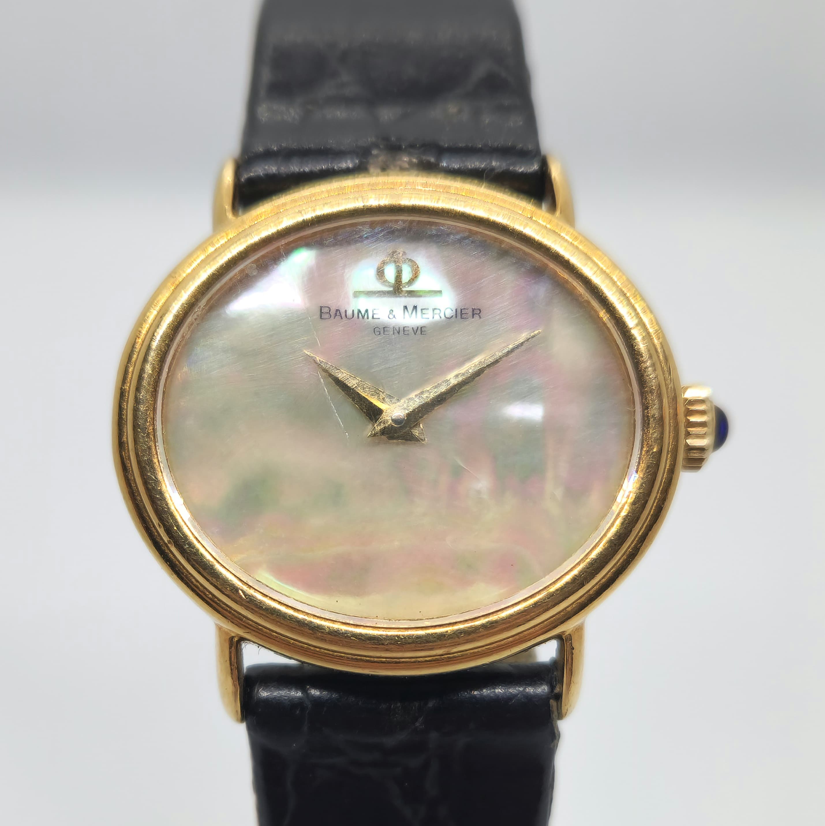 Reloj Baume & Mercier oro amarillo con esfera nácar iridiscente y correa negra en Joyería Recoleta