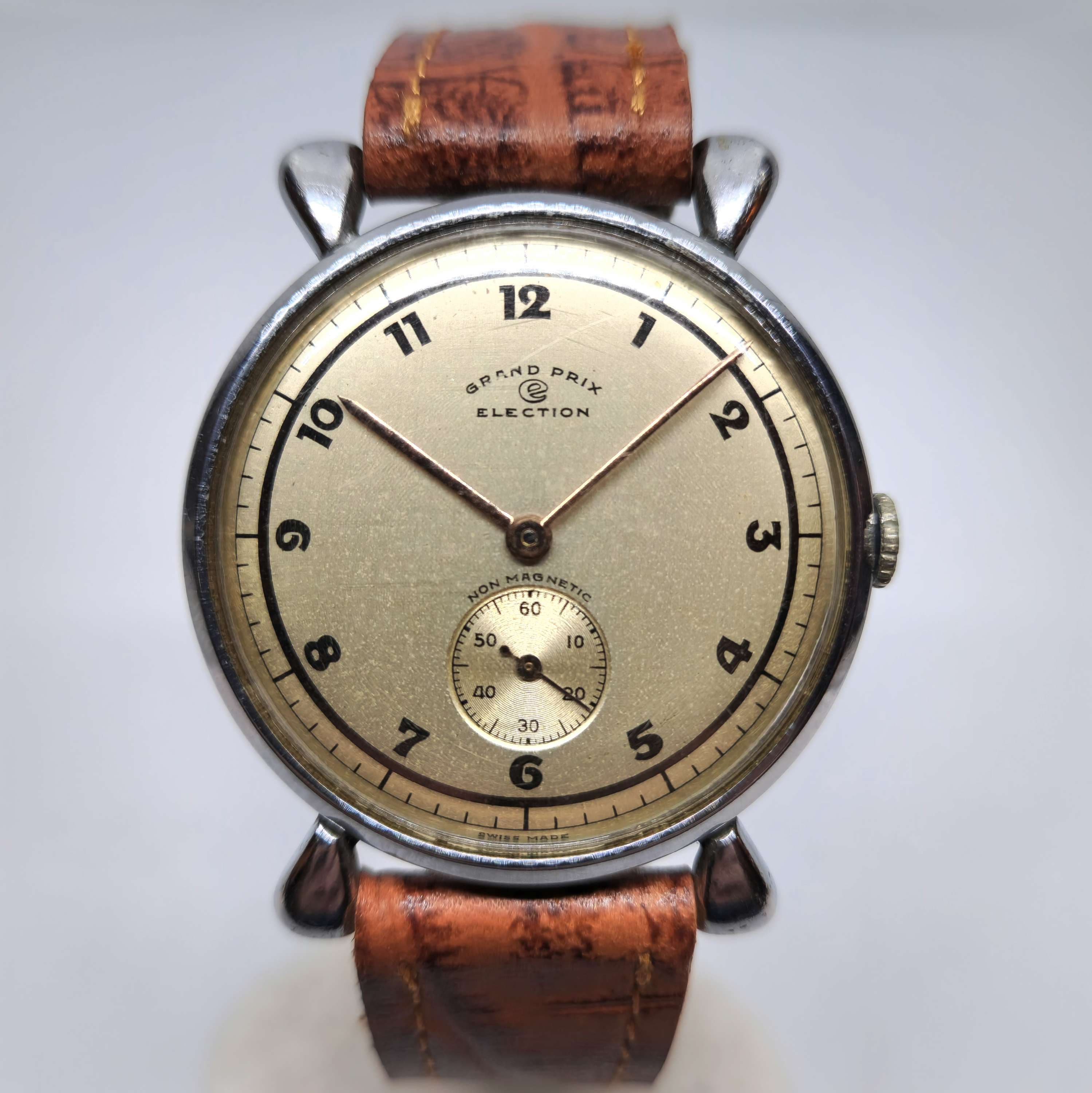 Reloj vintage Election Grand Prix acero con esfera dorada y segundero pequeño, años 50, en Joyería Recoleta.