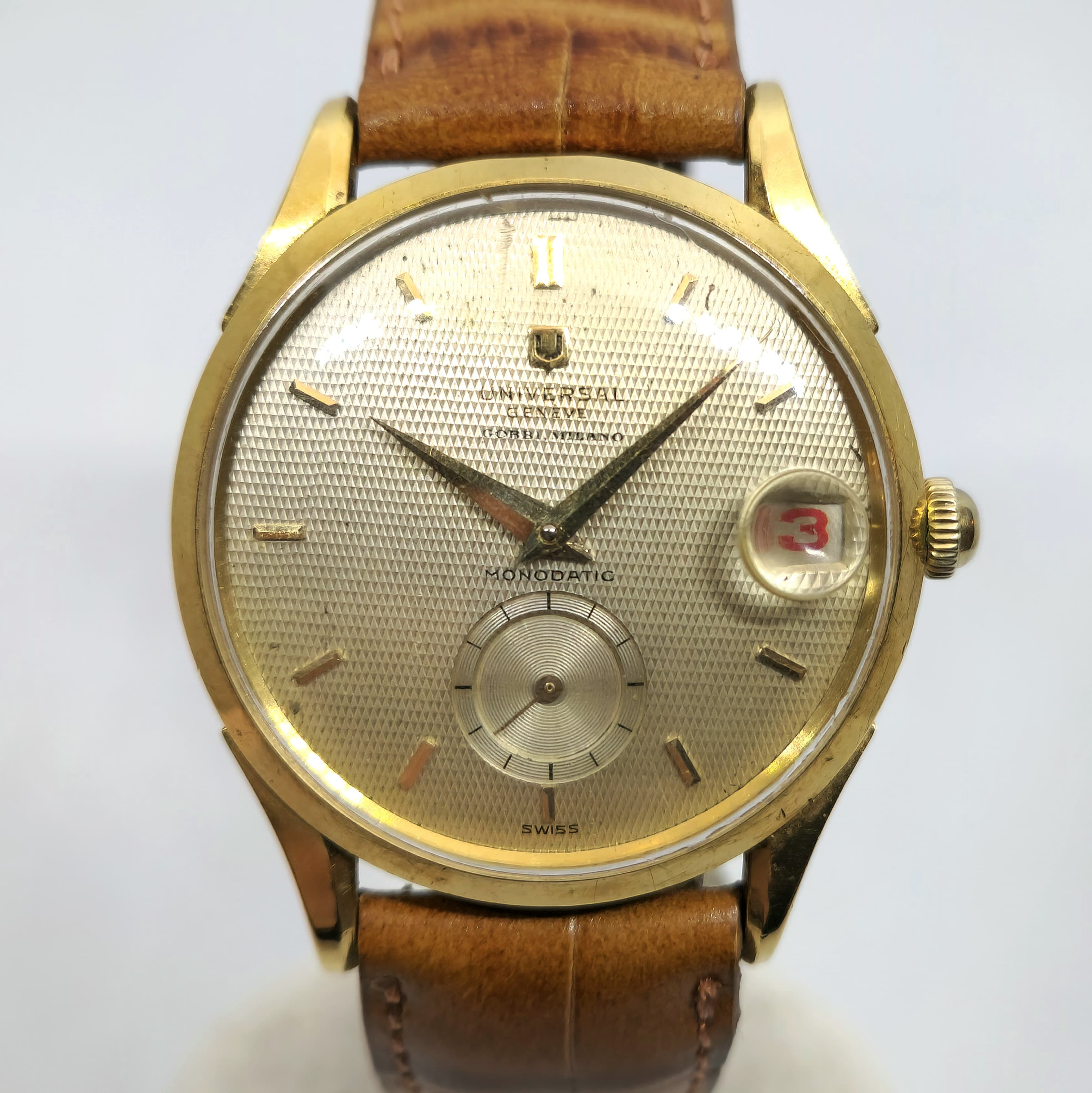 Reloj vintage Universal Genève Monodatic dorado con cuadrante guilloché y correa marrón en Joyería Recoleta.