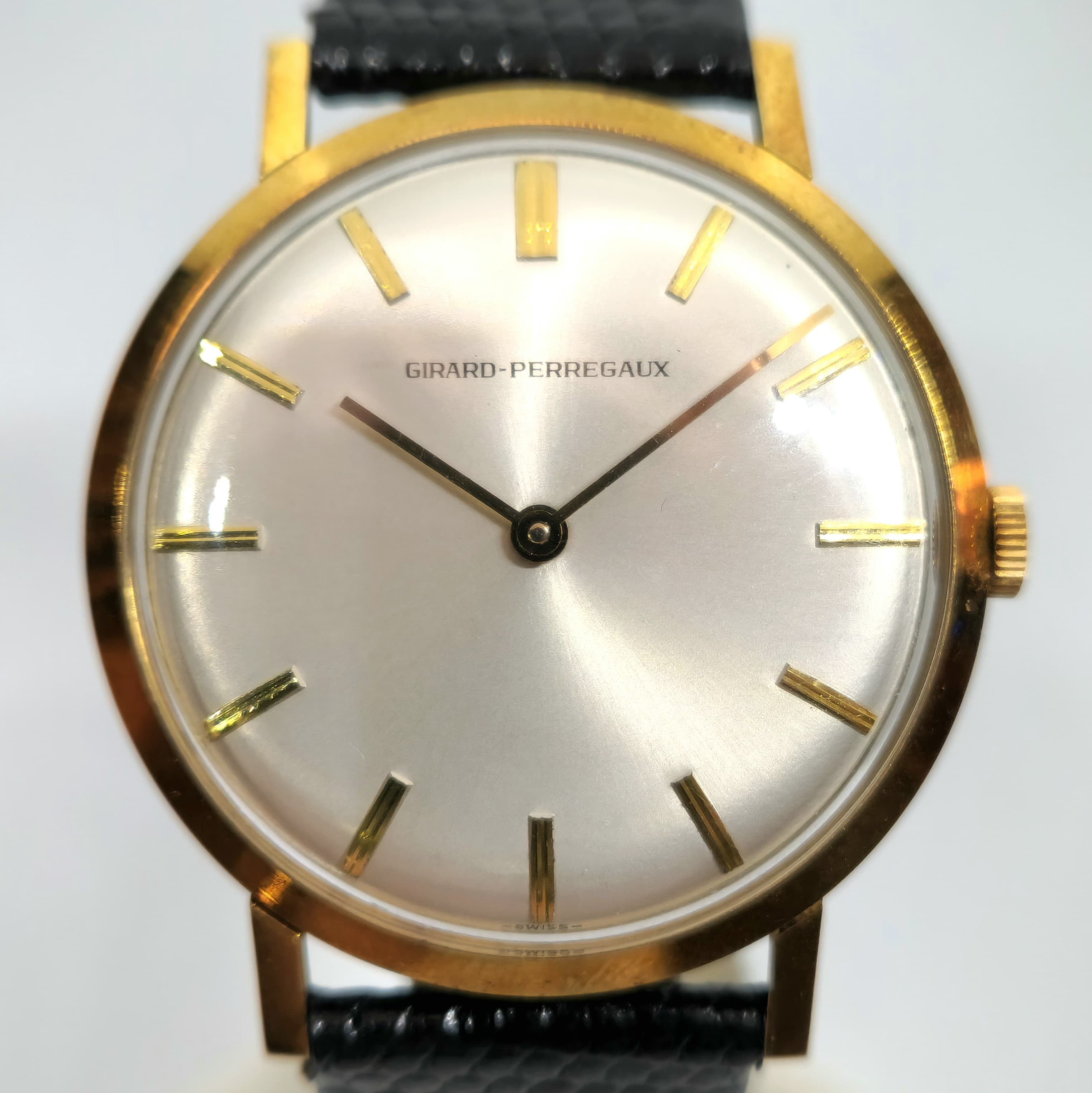 Reloj Girard-Perregaux de cuerda manual en oro amarillo con dial plateado sunray y correa negra en Joyería Recoleta.