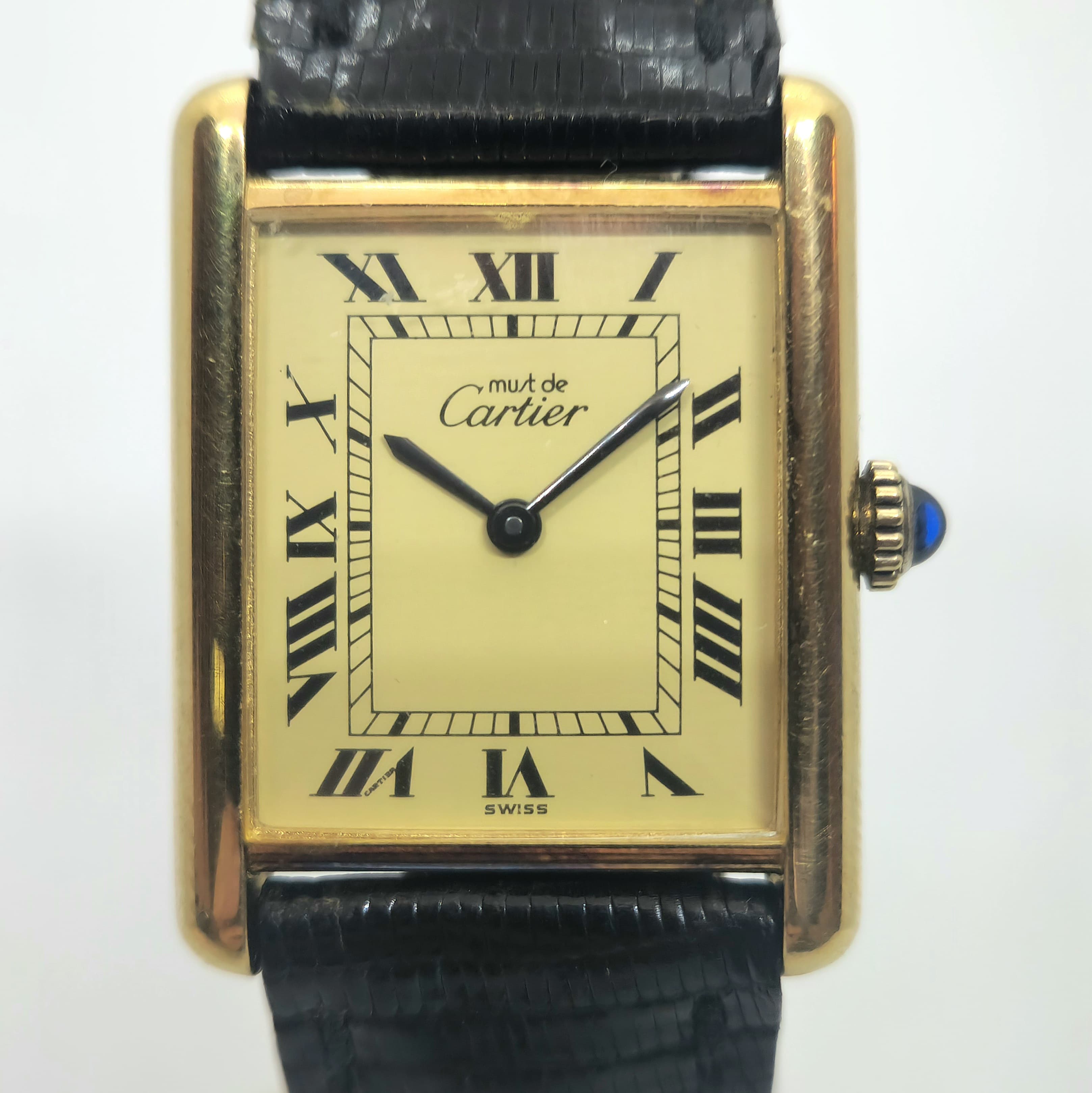 Reloj Must de Cartier Tank Vermeil dorado con dial crema, números romanos y correa negra en Joyería Recoleta.