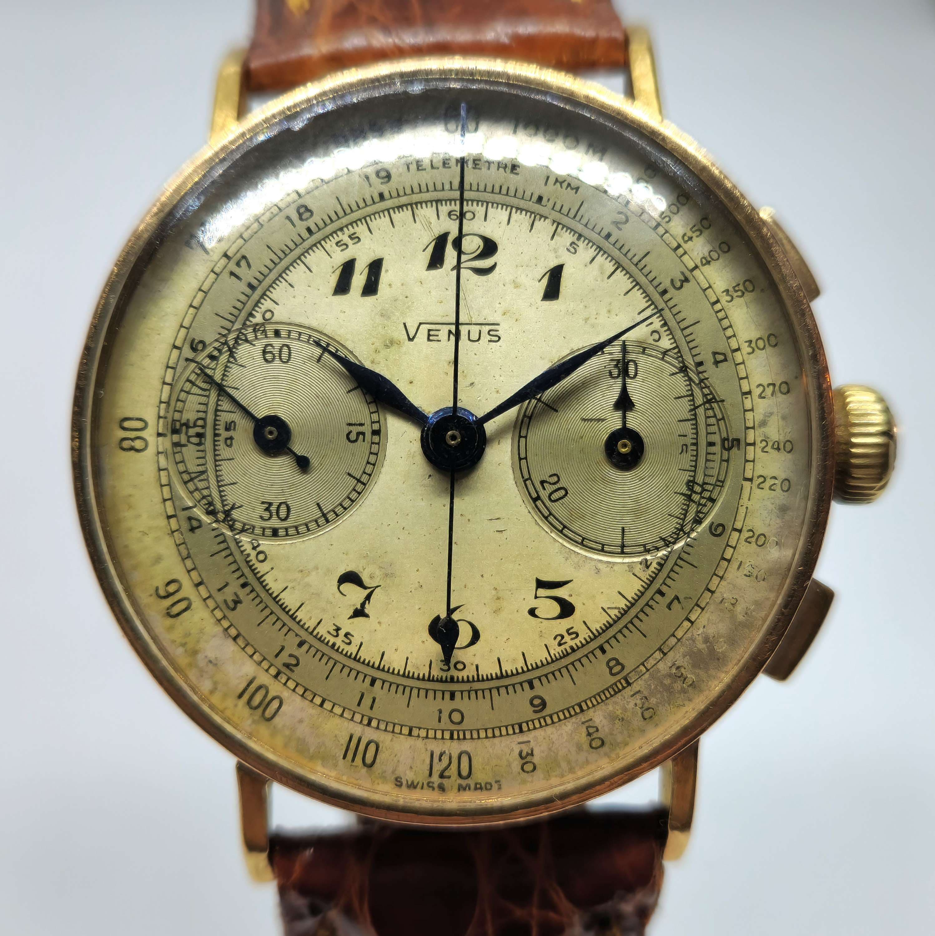 Reloj cronógrafo Venus vintage en oro amarillo con tacómetro y telémetro, correa marrón, en Joyería Recoleta.
