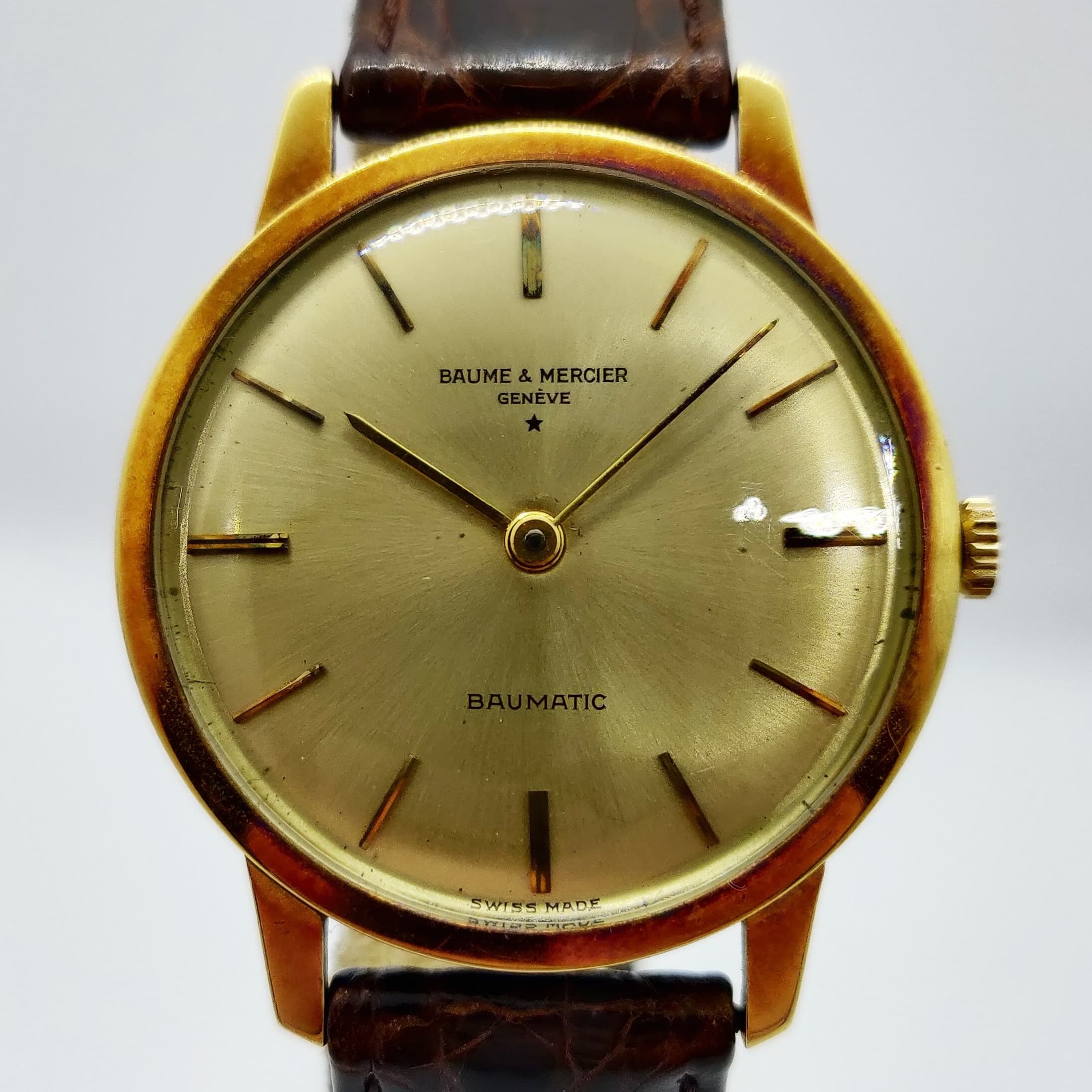 Reloj Baume & Mercier Baumatic vintage en oro amarillo con esfera champagne y malla de cuero marrón en Joyería Recoleta